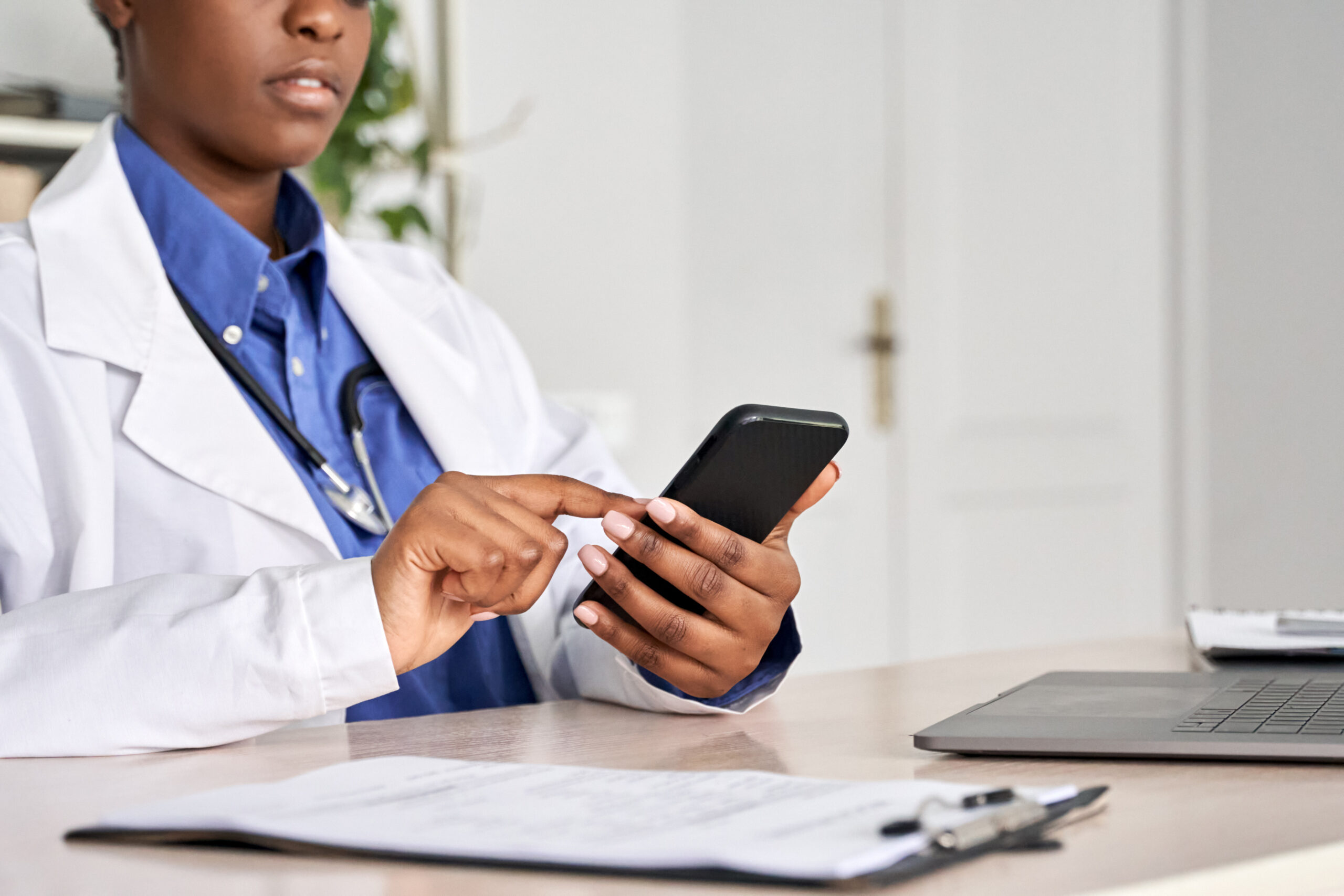 A female doctor holding a phone.